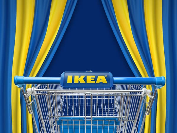 Un panier IKEA est poussé à travers des rideaux rayés bleu et jaune.