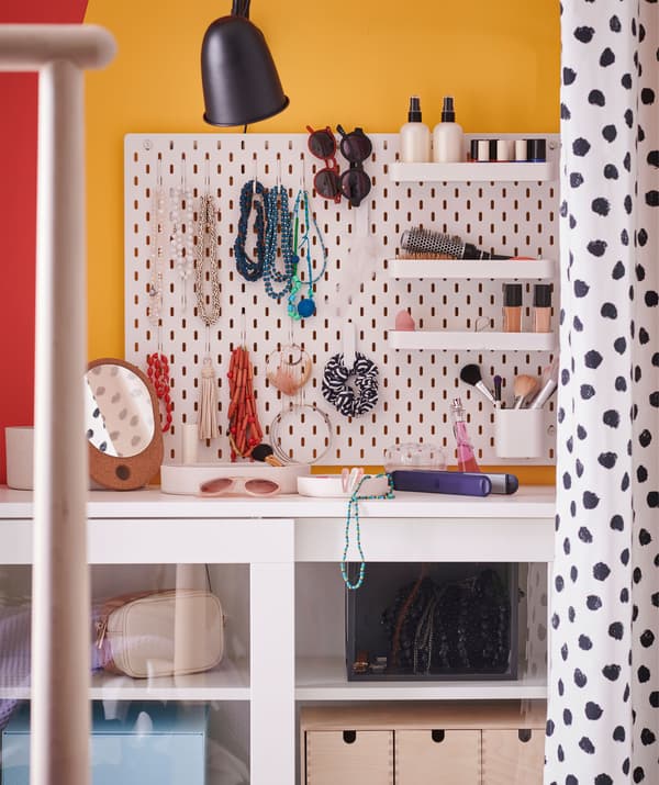Un pannello portaoggetti con ganci e piccole mensole tiene in ordine collane, bracciali, occhiali da sole e cosmetici - IKEA
