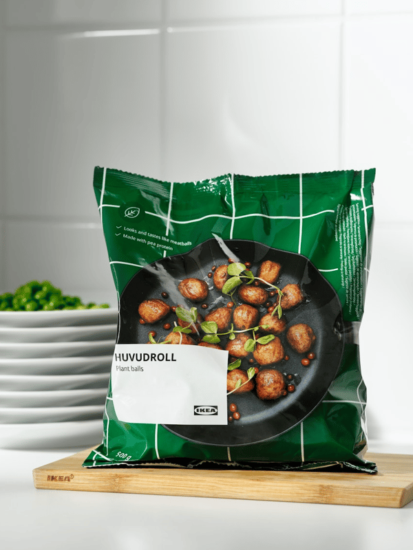 Un paquete de albóndigas HUVUDROLL de IKEA. El paquete es verde, muestra las albóndigas en un sartén y el fondo de la imagen también es verde.