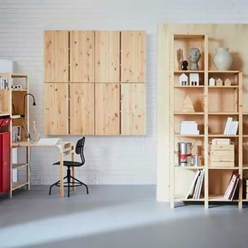 Un parete bianca di scaffali IVAR, tavoli allungabili IVAR e mobili da parete in legno.