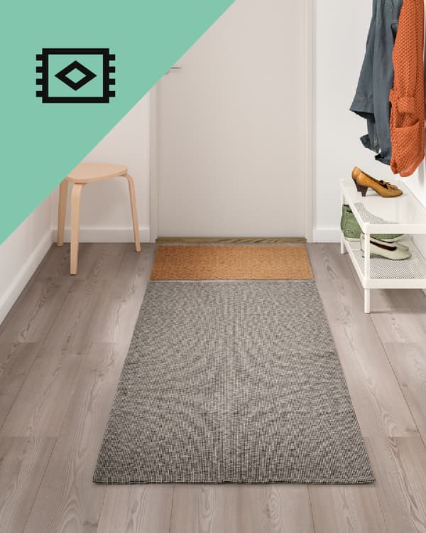 Un pasillo frente a una puerta con una alfombra de pasillo gris.