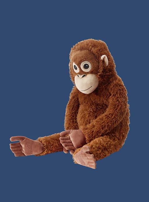 Un peluche orangután sobre un fondo azul.