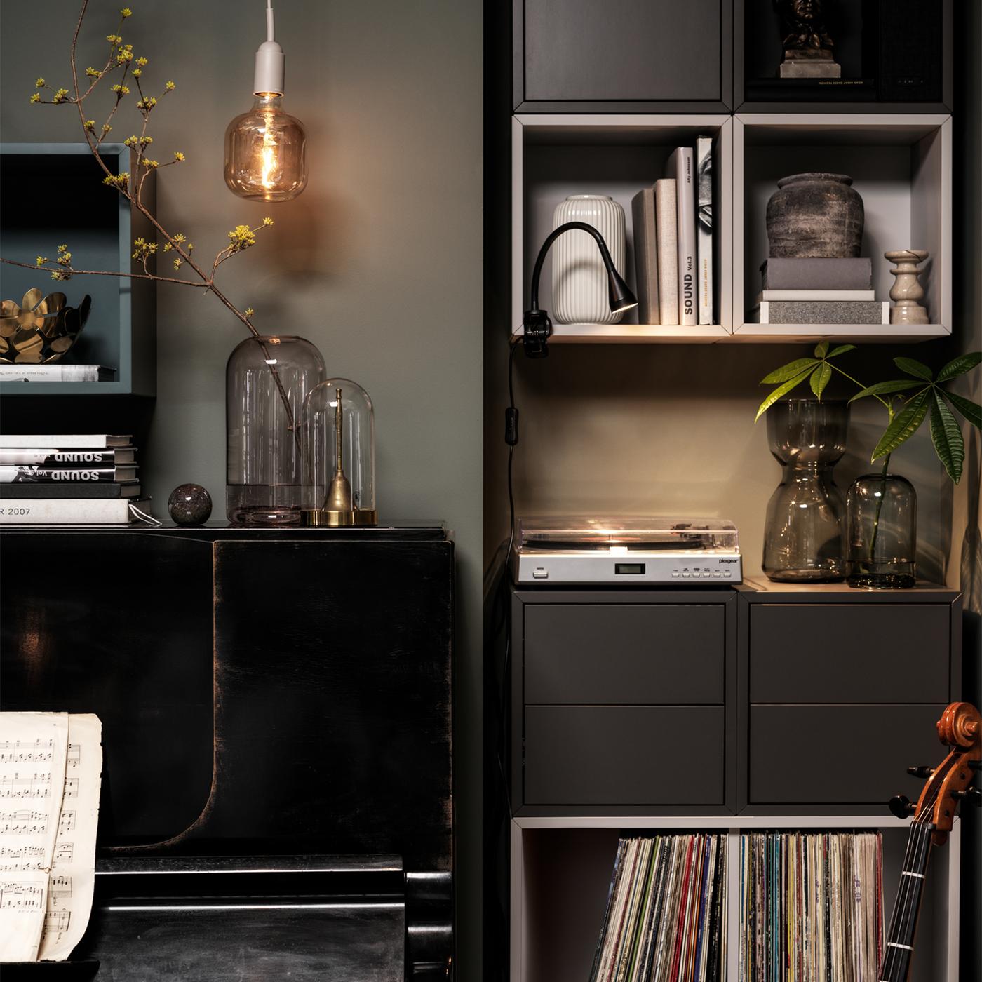 Un piano junto a una pared de estanterías y gabinetes EKET con un tocadiscos y discos.