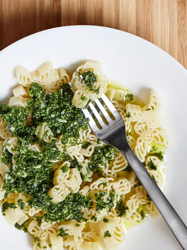 Un piatto di pasta con un condimento e una forchetta.