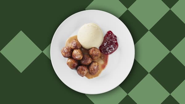 Un piatto di polpette con purè, salsa e marmellata di mirtilli rossi. 