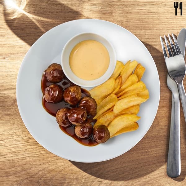 Un piatto di polpette Vegetali e Quali con salsa BBQ coreana accompagnate da patatine fritte e una cremosa salsa cheddar. 