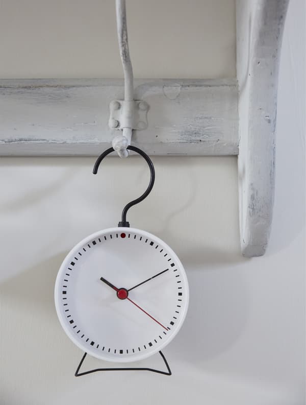 Un piccolo orologio appeso a un gancio dipinto.