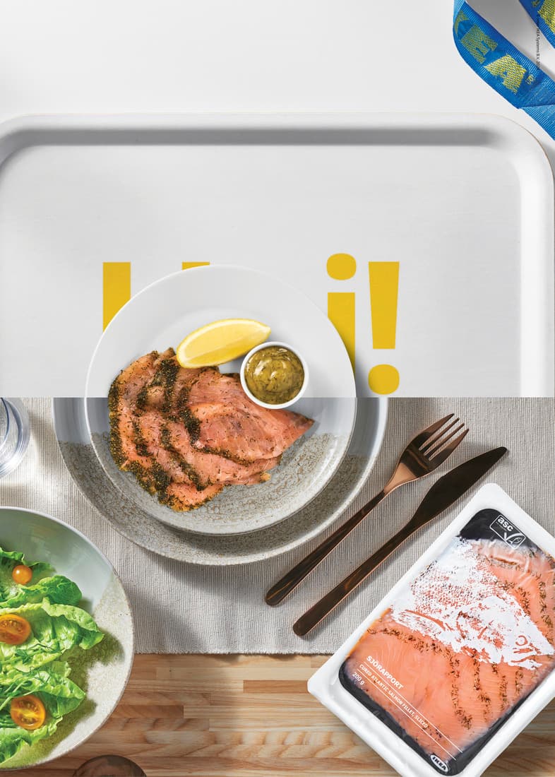 un plateau avec une assiette de saumon, de la sauce pour saumon et une tranche de citron, une assiette de salade et des couverts