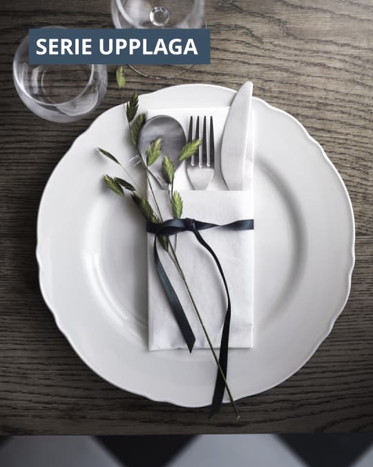 Un plato grande blanco de la Serie UPPLAGA con unos cubiertos encima del plato.