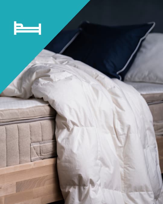 Un plumón ligero IKEA colgando del borde de una cama.