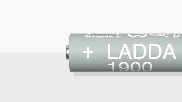 Un primo piano di una batteria ricaricabile LADDA, HR6 AA, su una superficie bianca e grigia.