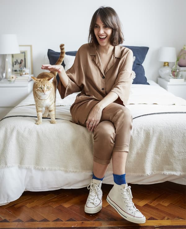 Un retrato de Carolina sentada na súa cama co seu gato.