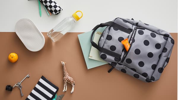 Un sac à dos ouvert avec un pochette bleu dépassant.
