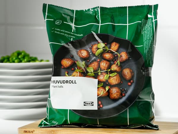 Un sac de boulettes végétales HUVUDROLL repose sur une planche à découper.