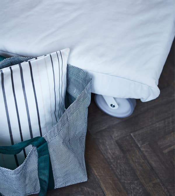 Un sac en polypropylène costaud mais élégant comme IKEA YPPERLIG peut servir de rangement pour le linge de lit des invités. Il possède un motif filet blanc et des poignées en nylon vertes ou bordeaux, pour un look moderne.