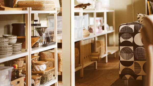 Un salon avec des étagères EKENABBEN contenant des bols GLADELIG, une cafetière HÖGMODIG et des boîtes avec couvercle.
