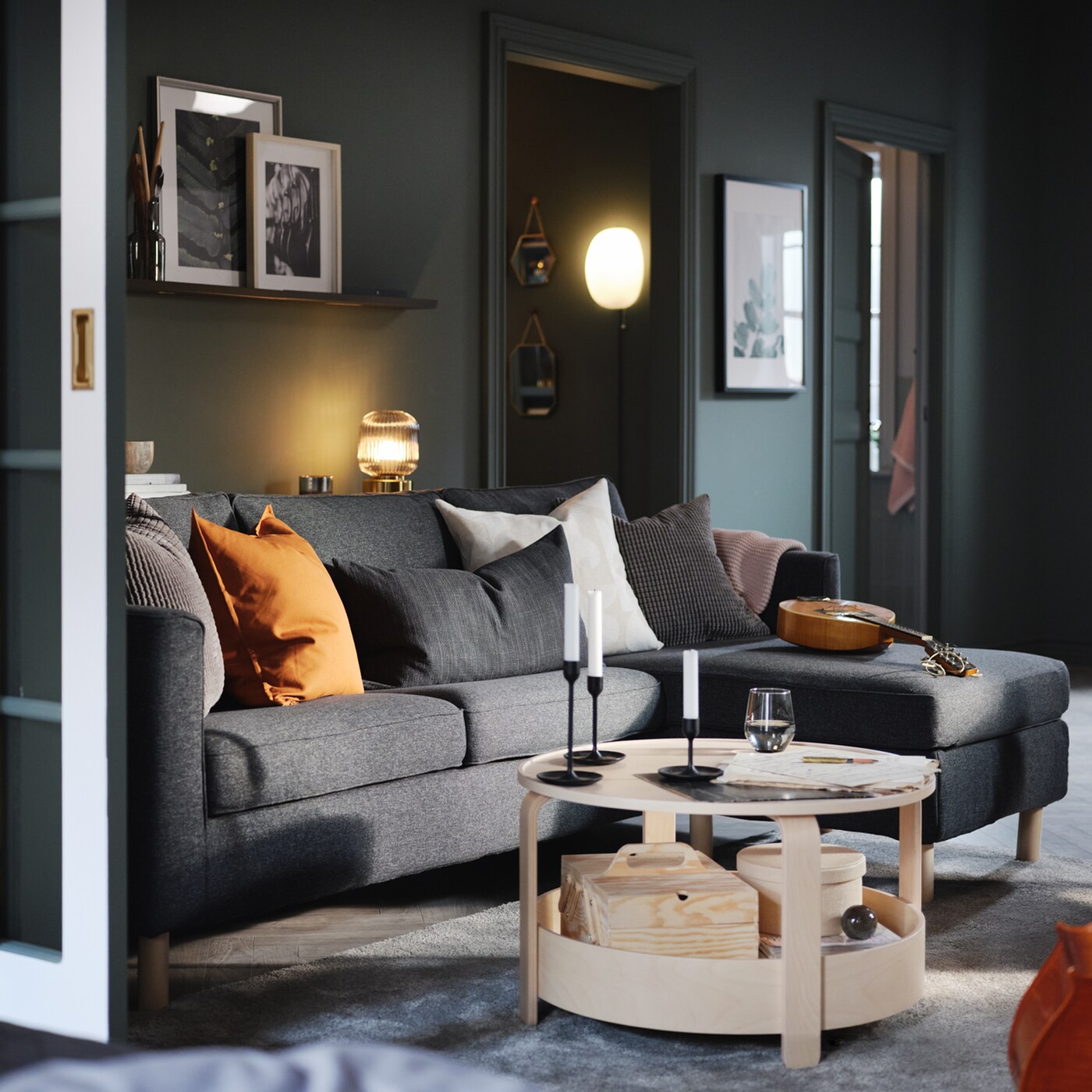 Un salón con un sofá con chaise longue y una mesa de centro.