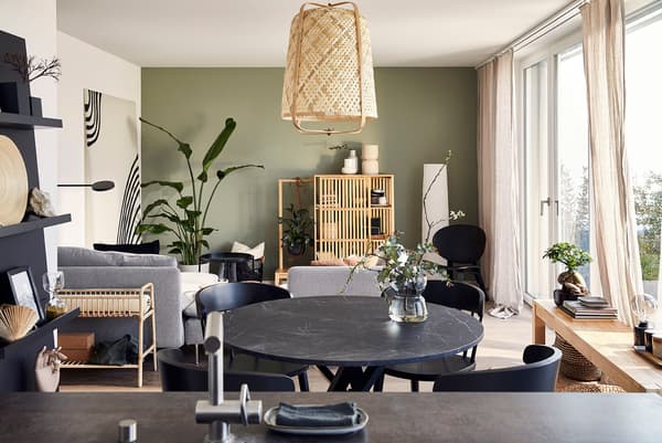 Un salon ouvert et une salle à manger décorés d'un style appaisant avec des meubles en bambou et en rotin.