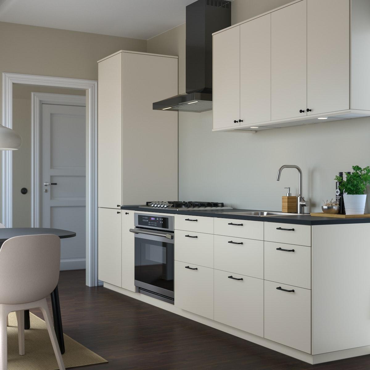 Un sistema componibile METOD con ante e frontali HAVSTORP bianche. Davanti c'è un tavolo e una sedia.