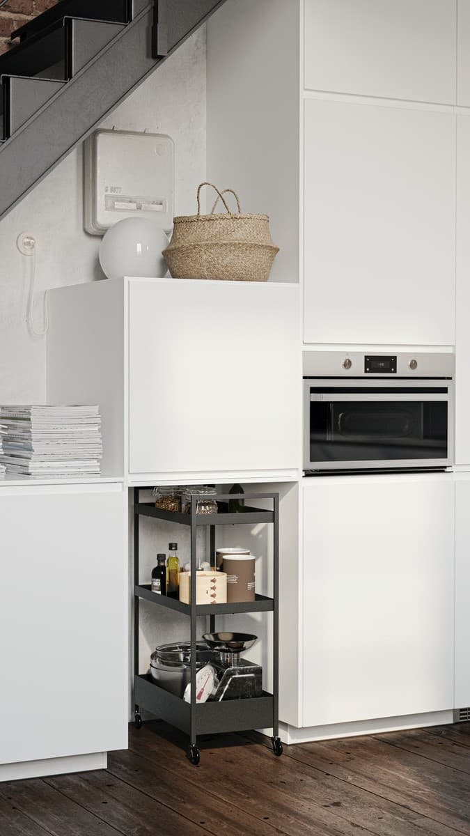 Un sistema componibile METOD, con frontali e ante VOXTORP bianco opaco con sotto un carrello NISSAFORS e sopra un cestino SMARRA.