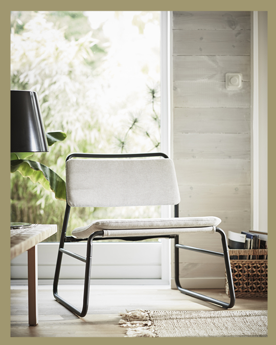 Un sitial IKEA en un living iluminado.