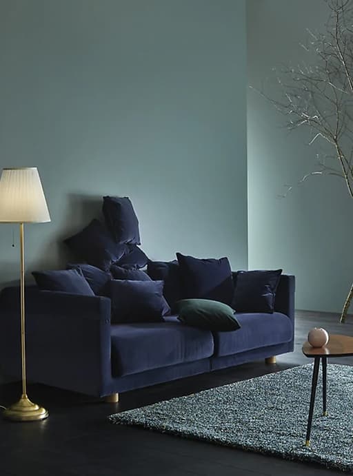 Un sofá de veludo azul escuro nun salón.