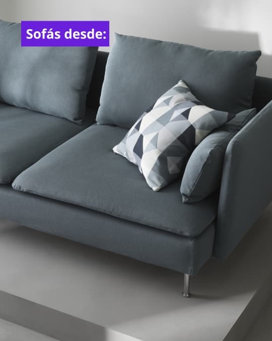 Un sofá gris de dos cuerpos apoyado en una pared blanca.