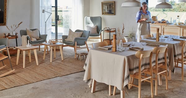 Un soggiorno arredato come sala da pranzo co tavoli e sedie LISABO.