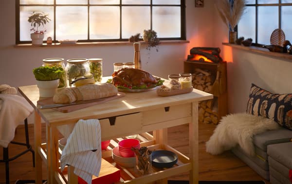 Un soggiorno in stile nordico con un camino elettrico in un angolo e un buffet su due carrelli al centro della stanza - IKEA