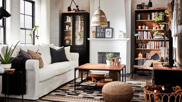 Un soggiorno in stile tradizionale con una libreria e un mobile TV in pino massiccio marrone-nero, un divano bianco e una vetrina - IKEA