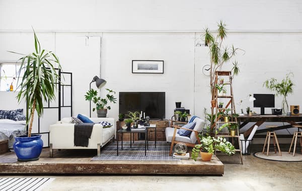 Un soggiorno open space e uno spazio di lavoro con soffitti alti e pavimenti in legno – IKEA