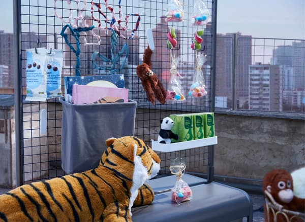 Un stand avec des snacks et des boissons placé sur un toit en pleine journée et surveillé par un tigre féroce.