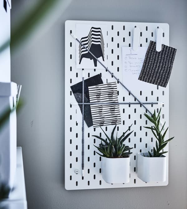 Un tauler IKEA SKÅDIS decorat amb plantes i notes.