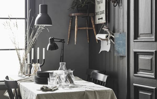 Un tavolo da pranzo con una tovaglia di lino in una cucina rustica moderna con decorazioni personali alla parete - IKEA.