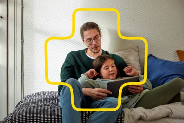 Un uomo e una bambina che condividono lo schermo di uno smartphone con le convenzioni di IKEA