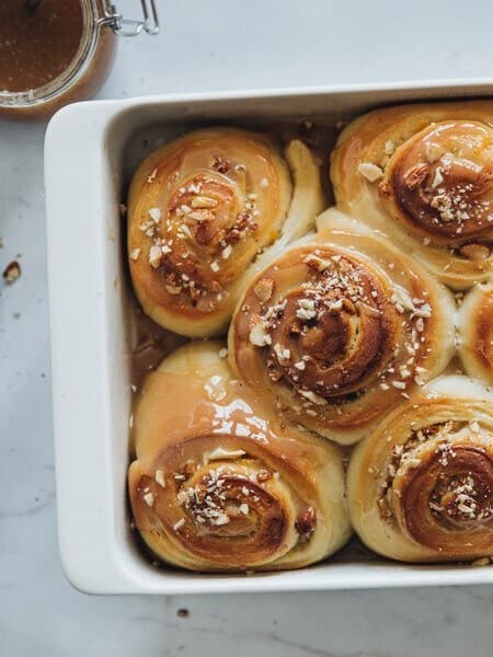 Un vassoio con dei panini vegani al lievito con caramello e sidro di mele appena sfornati.