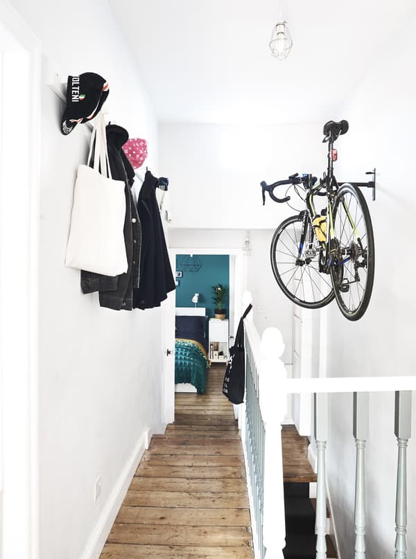Un vélo et des manteaux suspendus dans une entrée.