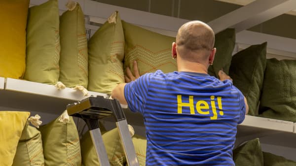 Un Visual Merchandiser d'IKEA dempeus davant un escriptori on està dibuixant.