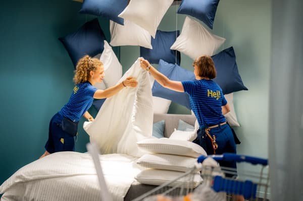 Un visual merchandiser IKEA disegna in piedi davanti a una scrivania.