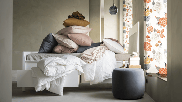 Una cama con ropa de cama blanca.