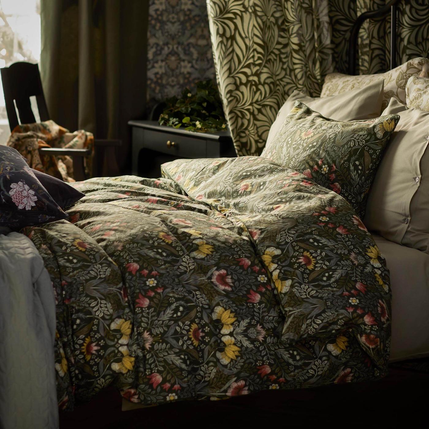 Una cama con una funda de verde duvet floral.