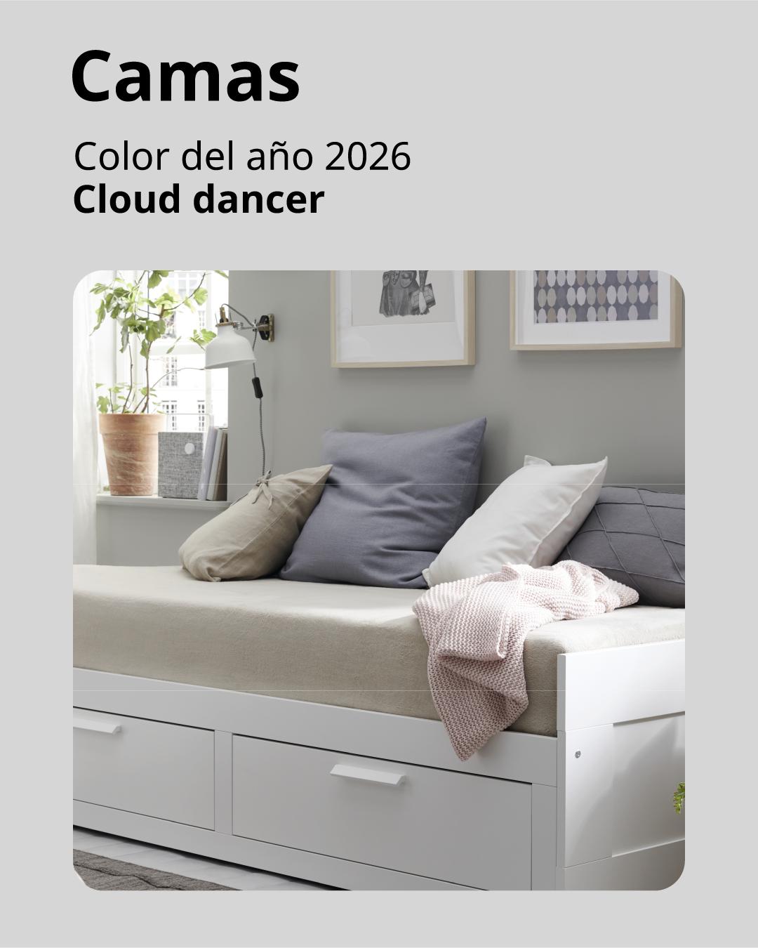 Una cama de invitados IKEA en un living pequeño con textiles y cojines. 