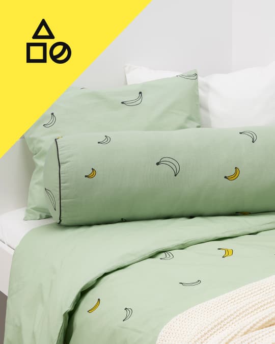 Una cama infantil con textiles von bananas dibujadas.