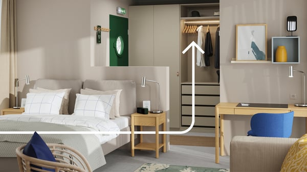 Una camera da letto con armadio PAX sullo sfondo e un letto con comodini color legno e una scrivania