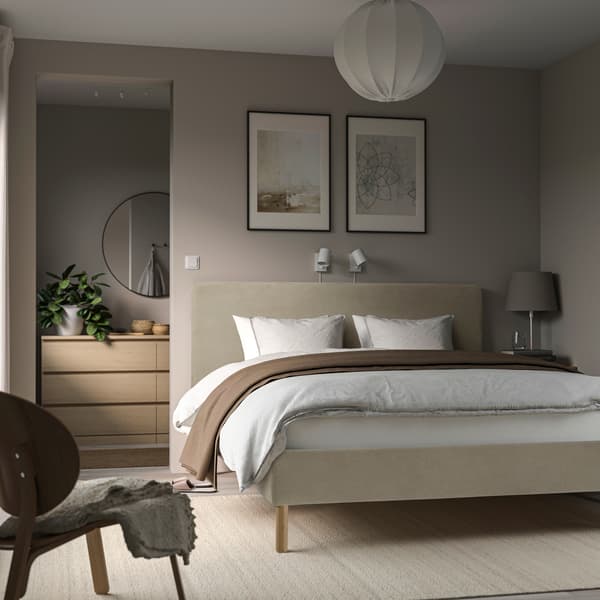 Una camera da letto con una porta dietro alla testata del letto che apre spazio ad una cabina armadio 