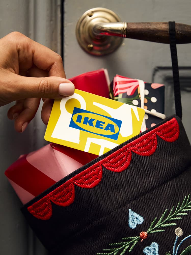 Una carta regalo IKEA inserita all'interno di un sacco con alcuni regali.