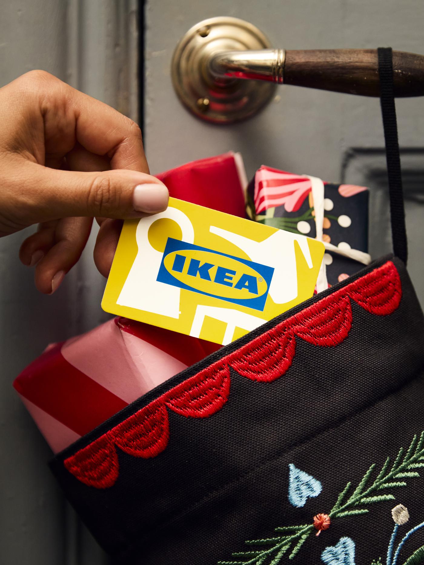 Una carta regalo IKEA inserita all'interno di un sacco con alcuni regali.