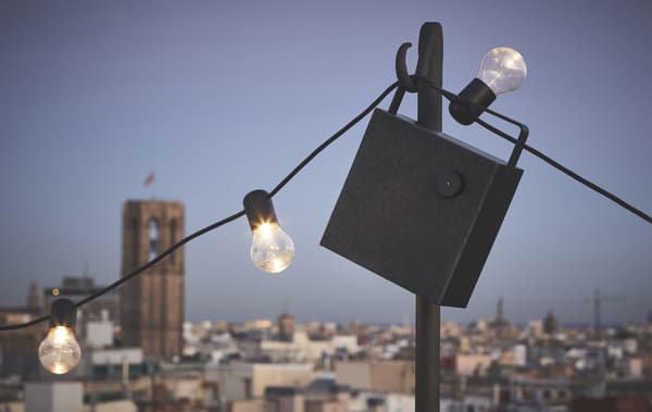 Una cassa nera Bluetooth® ENEBY e lampadine appese all'aperto - IKEA