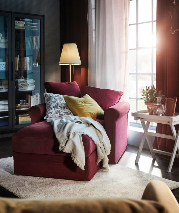 Una chaise-longue GRÖNLID amb una funda de xenilla suau TALLMYRA vermell fosc en una sala.