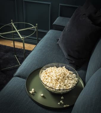 Una ciotola di pop corn appoggiata su un vassoio del tavolino GLADOM.